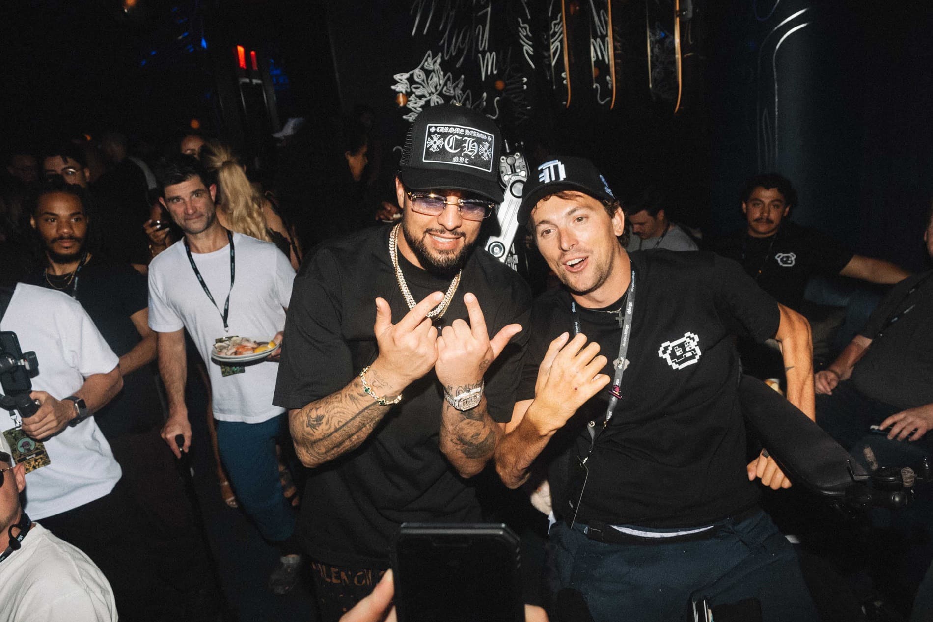 Crash (CrashMetaX) with a friend at a crowded night event, both making hang-loose signs